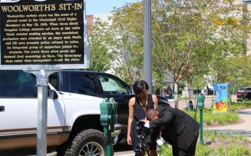 YMP students, Z'eani Furdge and Josh Wright, set up a film camera to cover the placard at the designated historical site of the former Woolworth's Diner that once held the 1963 sit-in. 